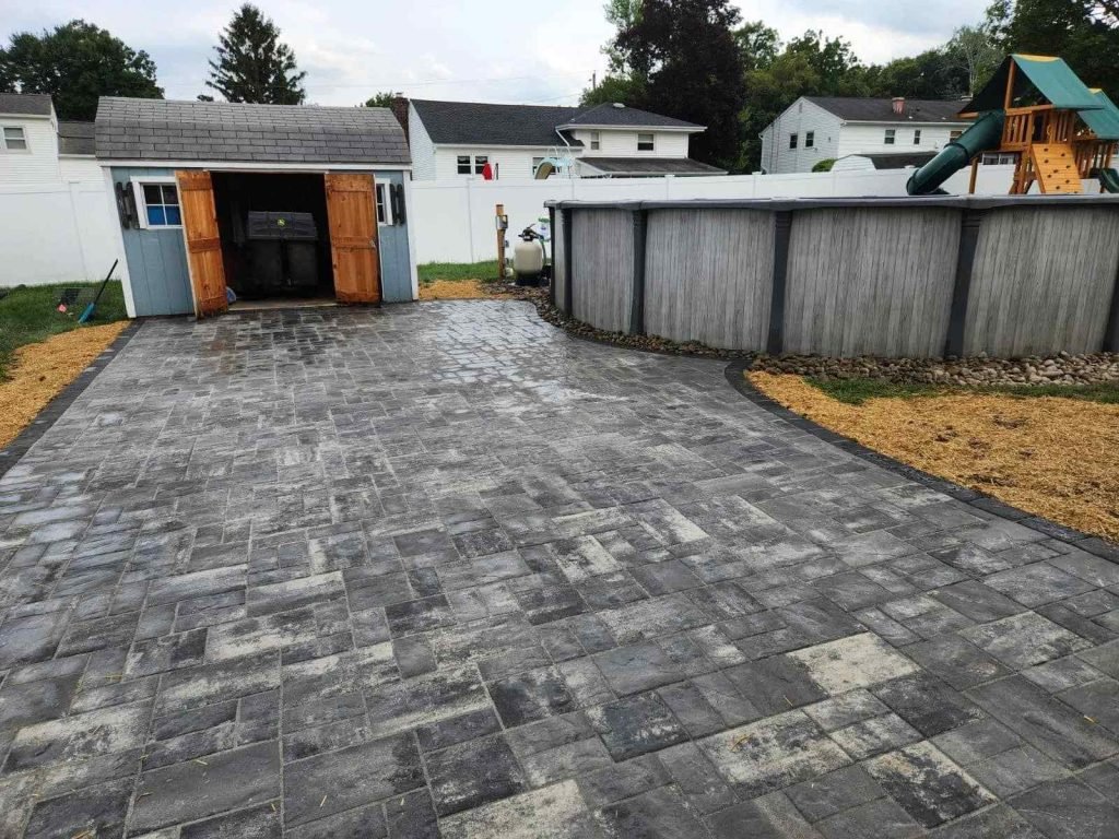 A driveway featuring brick pavers, leading to a shed, showcasing a recent pavers installation.